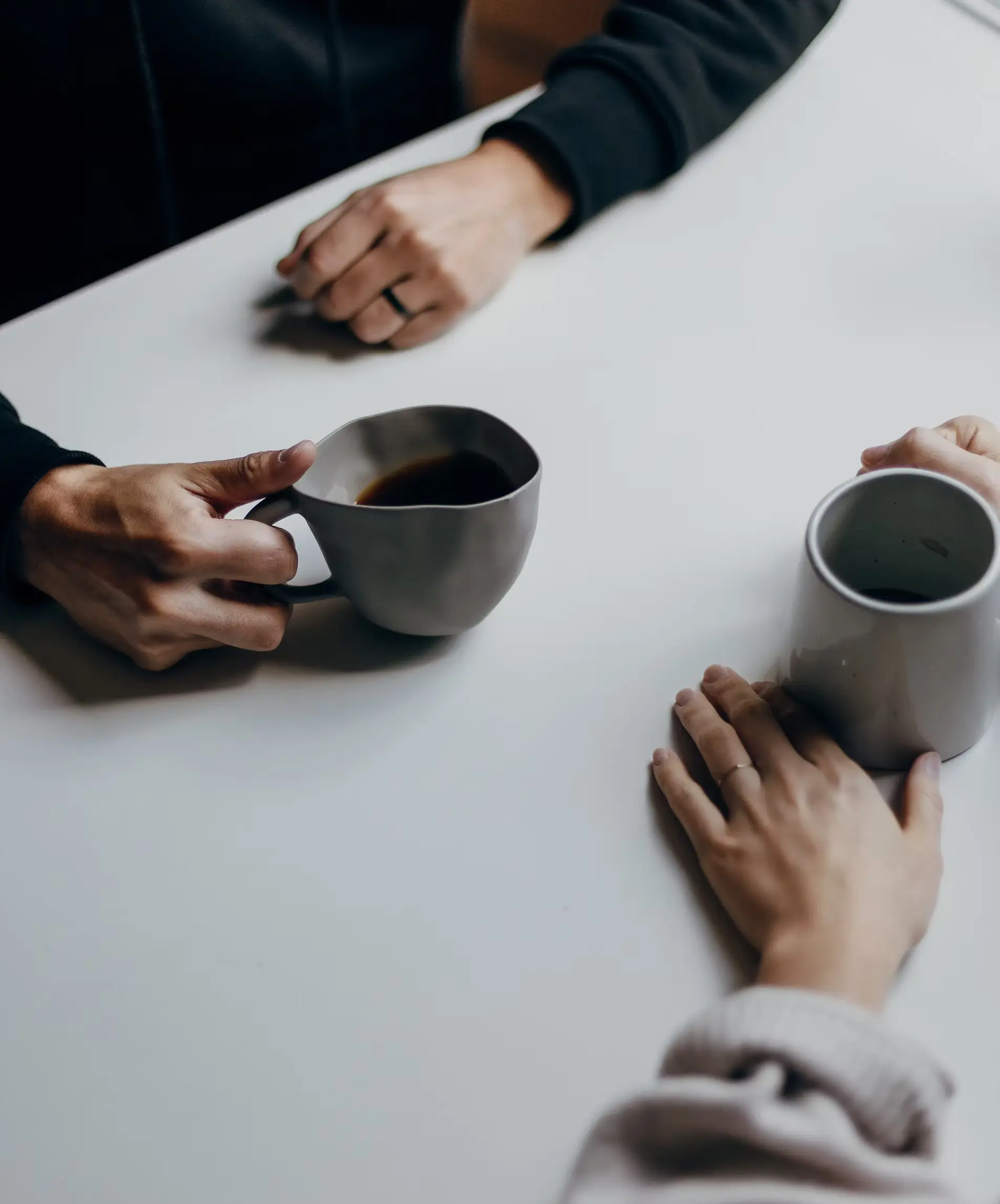 תמונת אוירה - יושבים סביב השולחן עם כוס קפה